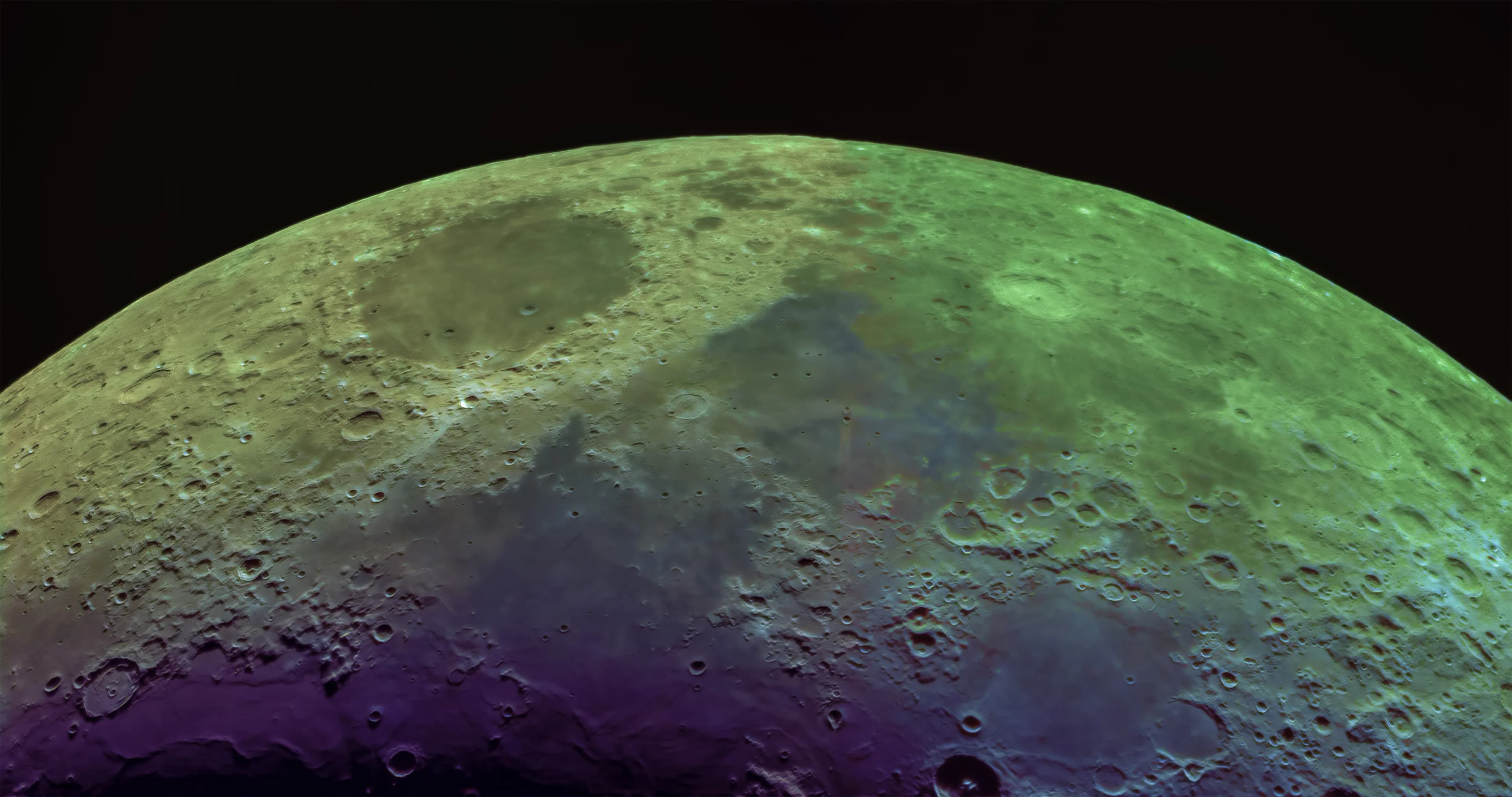 A wide lunar mosaic processed in mineral colors to show the geological diversity of the lunar surface.