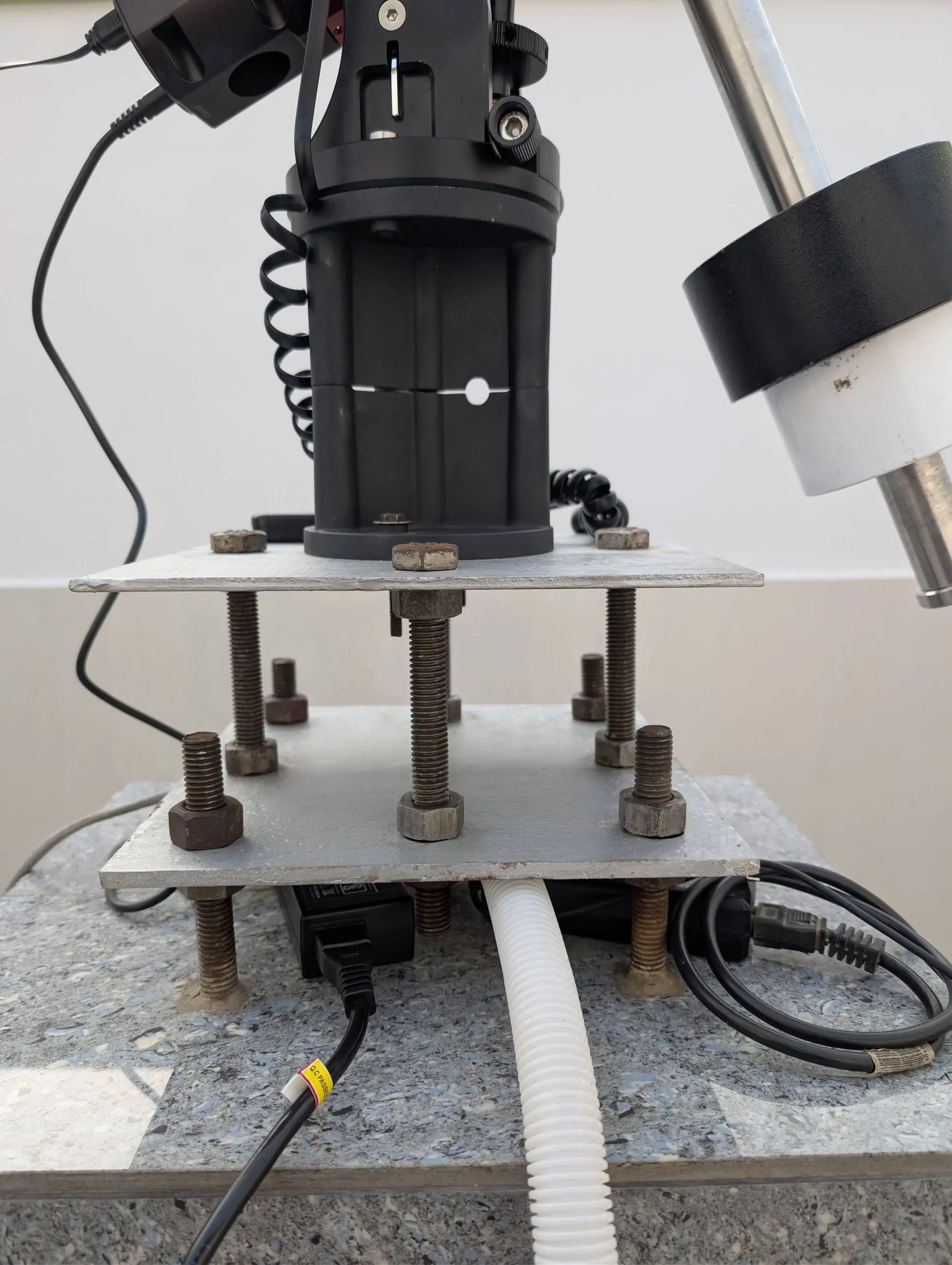 Close-up of the dual-plate steel telescope pier system leveled with an iOptron minipier extension